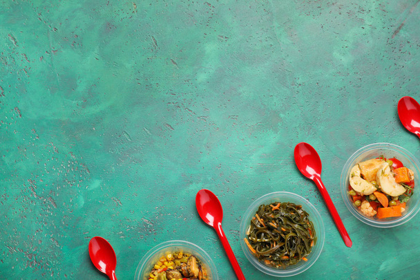 Renk arka plan üzerinde lezzetli yemekleri ile plastik kaplar - Fotoğraf, Görsel