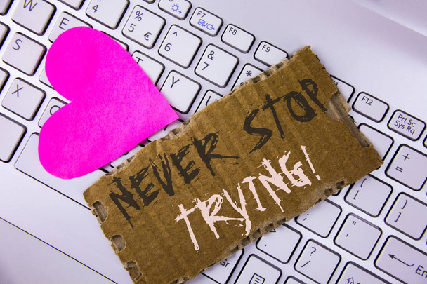 Word writing text Never Stop Trying Motivational Call. Business concept for go on do not give up Self confidence written on Tear Cardboard Piece placed on the Laptop Pink Heart next to it. - Photo, Image