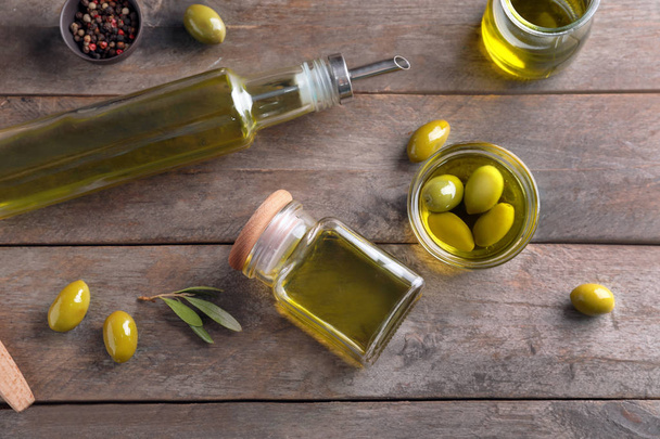Glassware with olive oil on wooden background - Zdjęcie, obraz