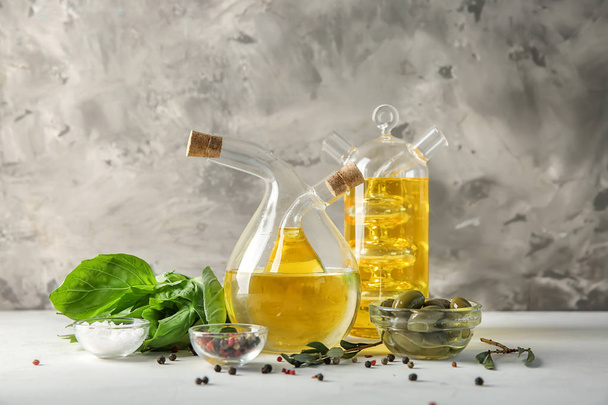 Öljyä ja oliiveja sisältävät pullot pöydällä
 - Valokuva, kuva