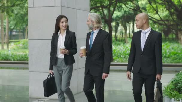 ejecutivos corporativos multiétnicos con café y bolsa de ordenador que llega al edificio moderno
. - Metraje, vídeo