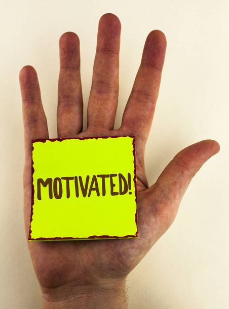 Handwriting text writing Motivated Motivational Call. Concept meaning Willing to do something Inspired Confident written on Sticky Note Paper placed on Hand on the plain background. - Photo, Image
