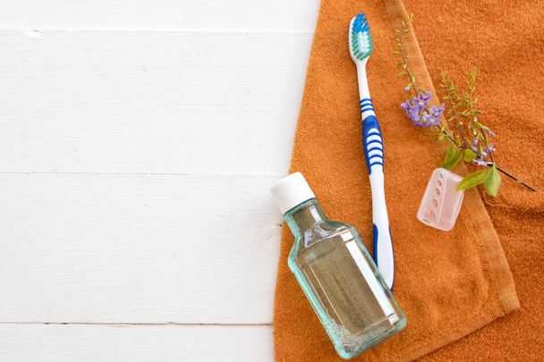 mouthwash and toothbrush for healthy care oral cavity with bath towel on background white - Photo, Image