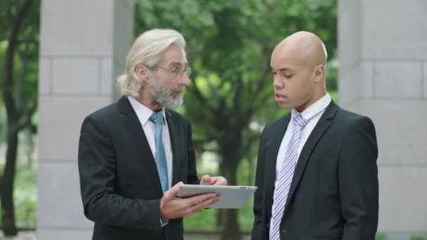şirket yöneticileri tartışırken iş dijital tablet kullanarak modern ofis lobisinde ayakta. - Video, Çekim