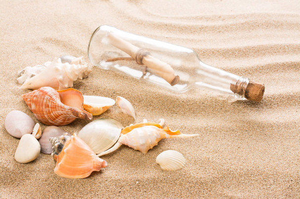 Message in bottle on the beach. Summer background with hot sand - Zdjęcie, obraz