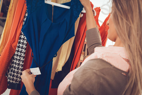 junge Frau wählt Kleidung in Boutique - Foto, Bild