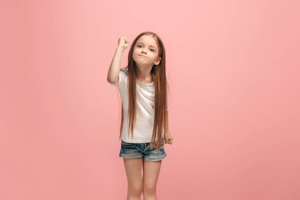 Portrait of angry teen girl on a pink studio background - Foto, imagen