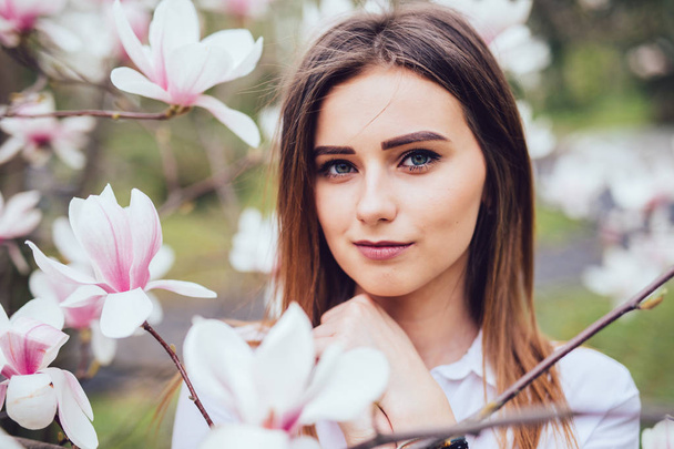 Půvab portrét mladé dívky poblíž květ magnólie květiny venku na jaře parku - Fotografie, Obrázek