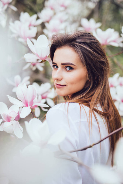 Retrato de dulce niña encantadora en Magnolia flores en flor
 - Foto, Imagen