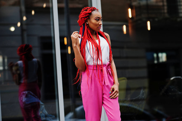 Fashionable african american girl at pink pants and red dreads p - Foto, immagini