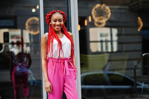 Fashionable african american girl at pink pants and red dreads p - Fotografie, Obrázek
