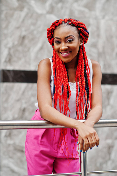Fashionable african american girl at pink pants and red dreads p - Photo, Image