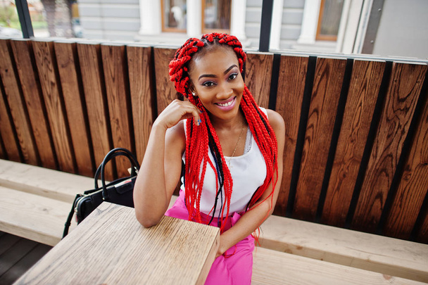 Fashionable african american girl at pink pants and red dreads p - Zdjęcie, obraz