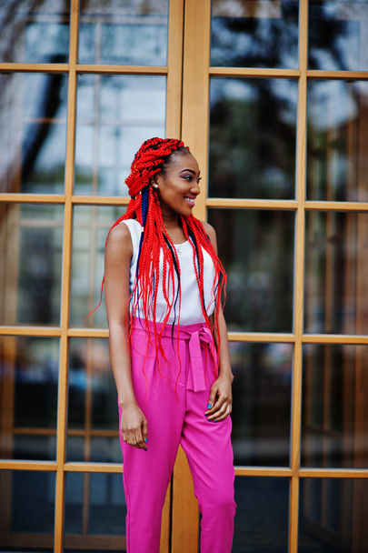 Fashionable african american girl at pink pants and red dreads p - Fotó, kép