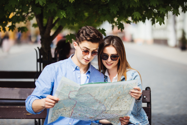 Sommerurlaub, Dating und Tourismuskonzept - lächelndes Touristenpaar mit Sonnenbrille und Stadtplan in der neuen Stadt - Foto, Bild