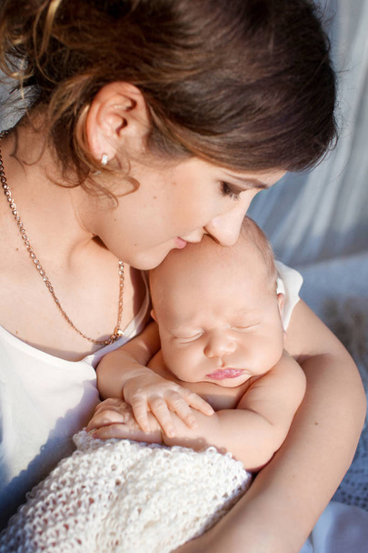 Pretty woman holding a newborn baby in her arms - Zdjęcie, obraz