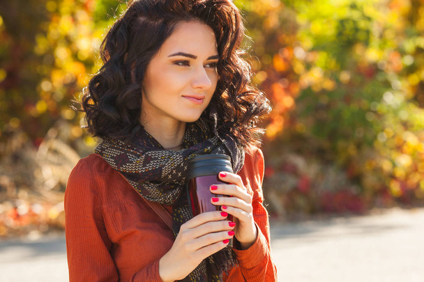 Młoda kobieta piękną filiżankę kawy lub herbaty na jesień. Portret atrakcyjna młoda dziewczyna na zewnątrz - Zdjęcie, obraz