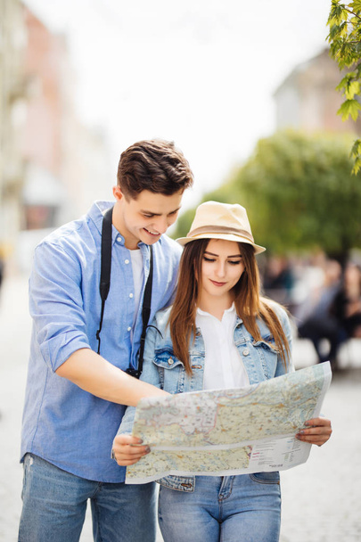 zomervakantie, dating en toerisme concept - lachend koppel in zonnebril met plattegrond in de stad - Foto, afbeelding