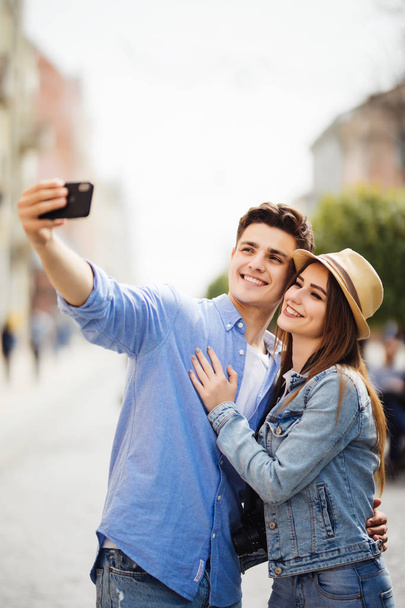 Lovely young tourist couple taking selfie phone on phone for memory spending time together at summer vocation. Discover new destination. - Photo, Image