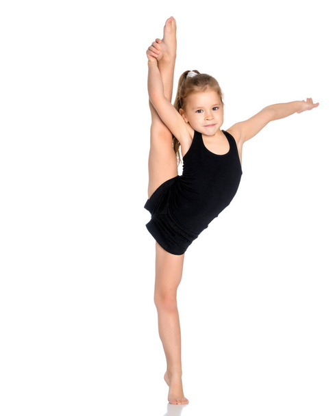 The gymnast balances on one leg. - Zdjęcie, obraz