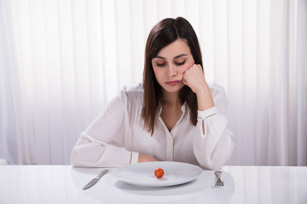 Young Woman Sitting With Plate Of Cherry Tomato At Breakfast - Foto, Imagem