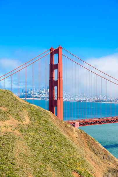 Golden Gate Bridge met de skyline van San Francisco op de achtergrond op een mooie zonnige dag met blauwe lucht en de wolken in de zomer - panoramisch uitzicht vanaf de batterij Spencer - San Fancisco Bay Area, Golden Gate National Recreation Area, California, Usa - Foto, afbeelding