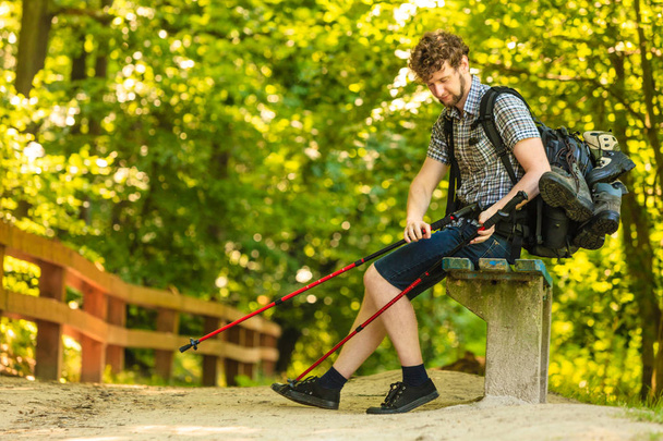 man hiker with backpack resting on bench in forest trail - Fotoğraf, Görsel