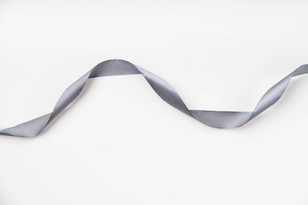 curled gray silk ribbon on white background with copy space - Zdjęcie, obraz