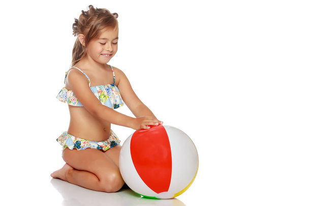 Little girl in a swimsuit with a ball - Foto, imagen