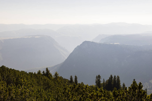 ディナル ・ アルプス山脈、モンテネグロのドゥルミトル国立公園にかすんでいる日中谷 - 写真・画像