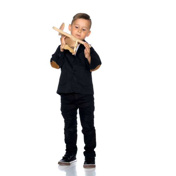 Little boy playing with wooden plane - Fotografie, Obrázek