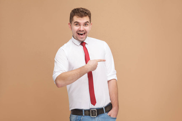 happy smiling man showing finger at copy space on light brown background - Foto, immagini