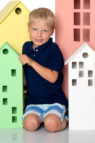 A little boy is playing with colorful houses. - Foto, Imagem