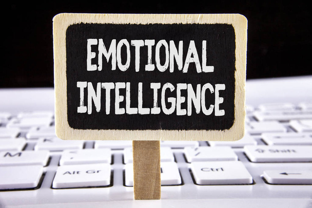 Word pisanie tekstu inteligencji emocjonalnej. Koncepcja biznesowa dla zdolności do kontroli i być świadomi osobiste emocje zapisane na drewnianej tablicy ogłoszeń umieszczonych na laptopie. - Zdjęcie, obraz