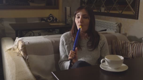 Μελαχρινή γυναίκα σε ένα καφέ κάπνισμα ναργιλέ - Πλάνα, βίντεο