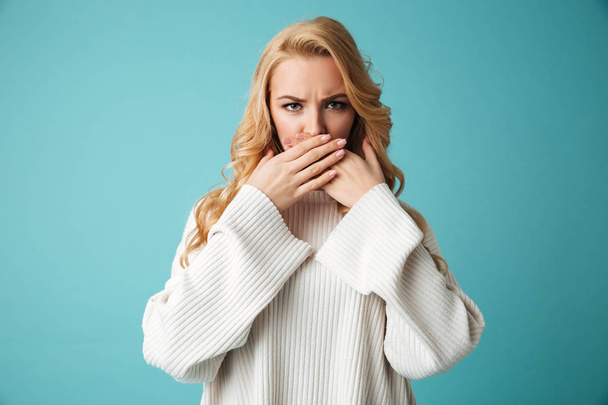 Portrait of an angry young blonde woman in sweater - 写真・画像