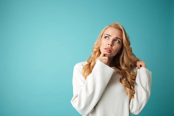 Portrait of a pensive young blonde woman in sweater - Photo, Image
