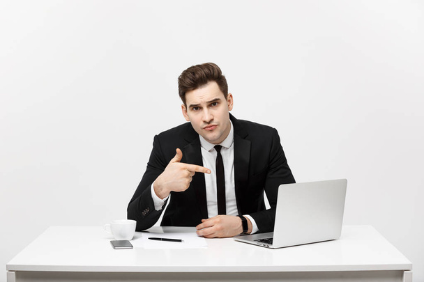 hombre de negocios sentado en el dedo del escritorio en la pantalla aislada del ordenador portátil, joven hombre de negocios guapo mirando a la cámara, sobre fondo blanco
 - Foto, Imagen
