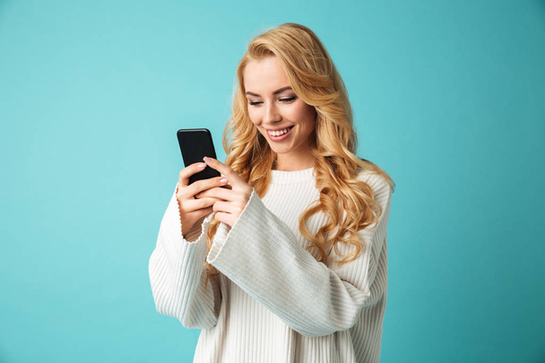 Portrait of a smiling young blonde woman in sweater - Foto, Imagen