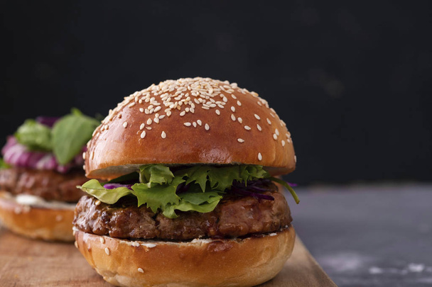 Delicious fresh homemade burger on a wooden table. - Фото, зображення