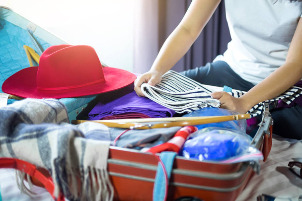 Travel and vacation concept, happiness woman packing stuff and a - Foto, Imagen