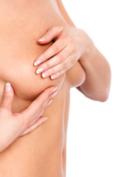 Donna nuda esaminando il seno, isolata su sfondo bianco
 - Foto, immagini