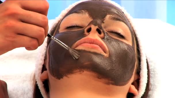 mladá brunetka s obličeji pleťovou masku - Záběry, video
