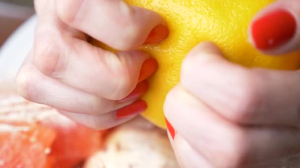 Female hands cleanse the grapefruit. 4k, close-up, slow-motion - Кадры, видео