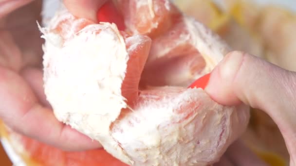 Female hands cleanse the grapefruit. 4k, close-up, slow-motion - Felvétel, videó
