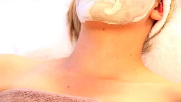 Young blonde girl resting with facial skin mask - Filmmaterial, Video