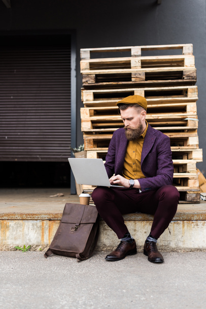 Bonito homem de negócios em roupas de estilo vintage digitando no teclado do laptop
 - Foto, Imagem