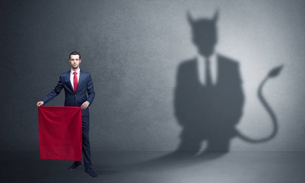 悪魔の影と闘牛士のコンセプトを持ったビジネスマン - 写真・画像