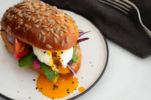 Fresh avocado breakfast with egg benedict sandwich. Green salad and seeds, healthy vegetarian food concept. Food background, copy space. - Foto, imagen