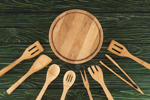 верхний вид круглых досок и деревянных кухонных принадлежностей на столе
  - Фото, изображение